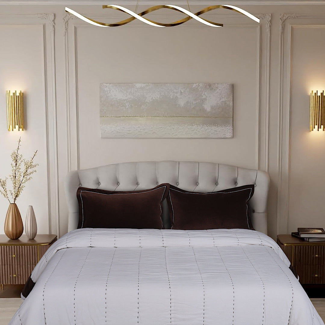White quilt with chocolate-brown border styled on a modern bed
